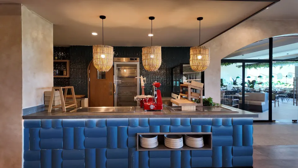 Service counter with blue padded front and hanging woven lamps at Grand Sirenis Riviera Maya Resort & Spa