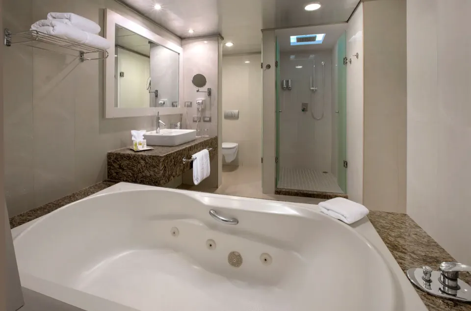 Corner view of whirlpool tub, vanity and glass shower in a Deluxe Junior Suite at Grand Sirenis Riviera Maya Resort & Spa