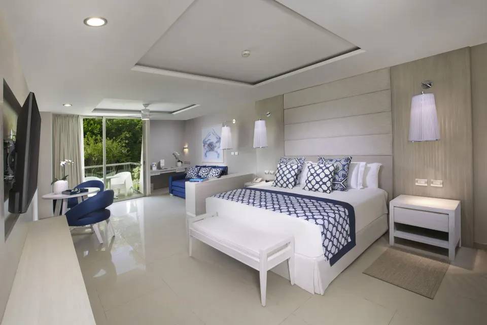 Spacious bedroom with king bed and balcony in a Deluxe Junior Suite at Grand Sirenis Riviera Maya Resort & Spa