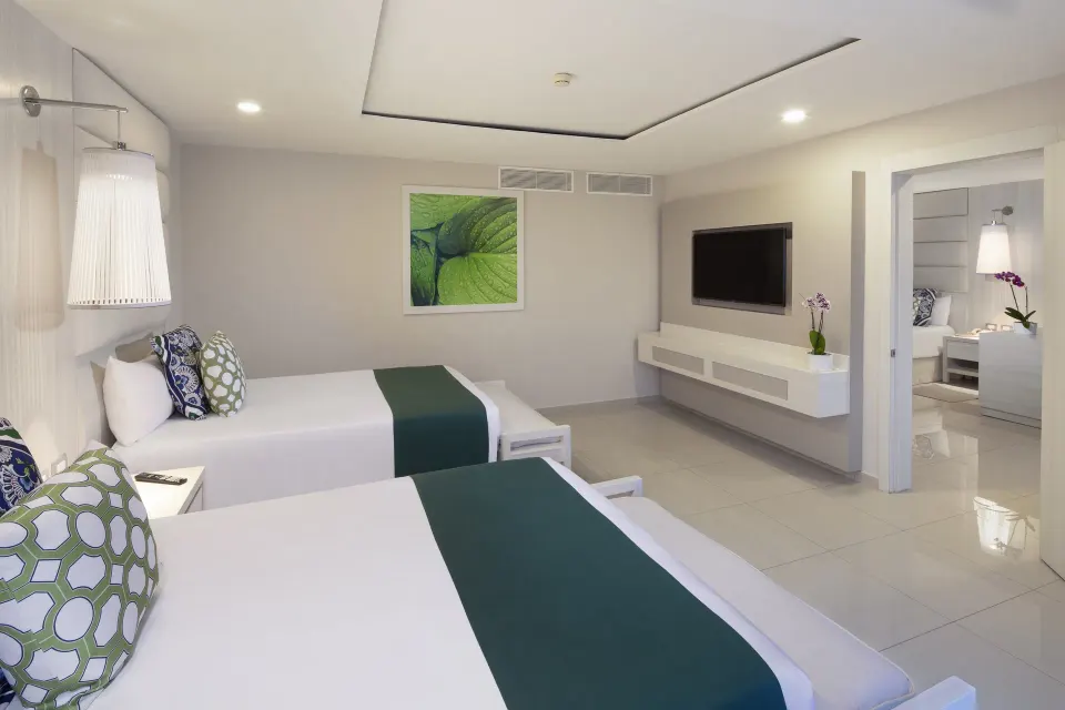 Mini suite with two beds and wall-mounted TV at Grand Sirenis Riviera Maya Resort & Spa