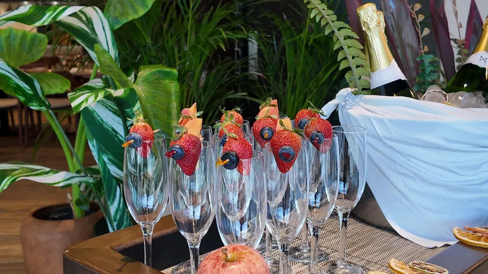 Champagne flutes garnished with strawberries on a serving table at Grand Sirenis Riviera Maya Resort & Spa