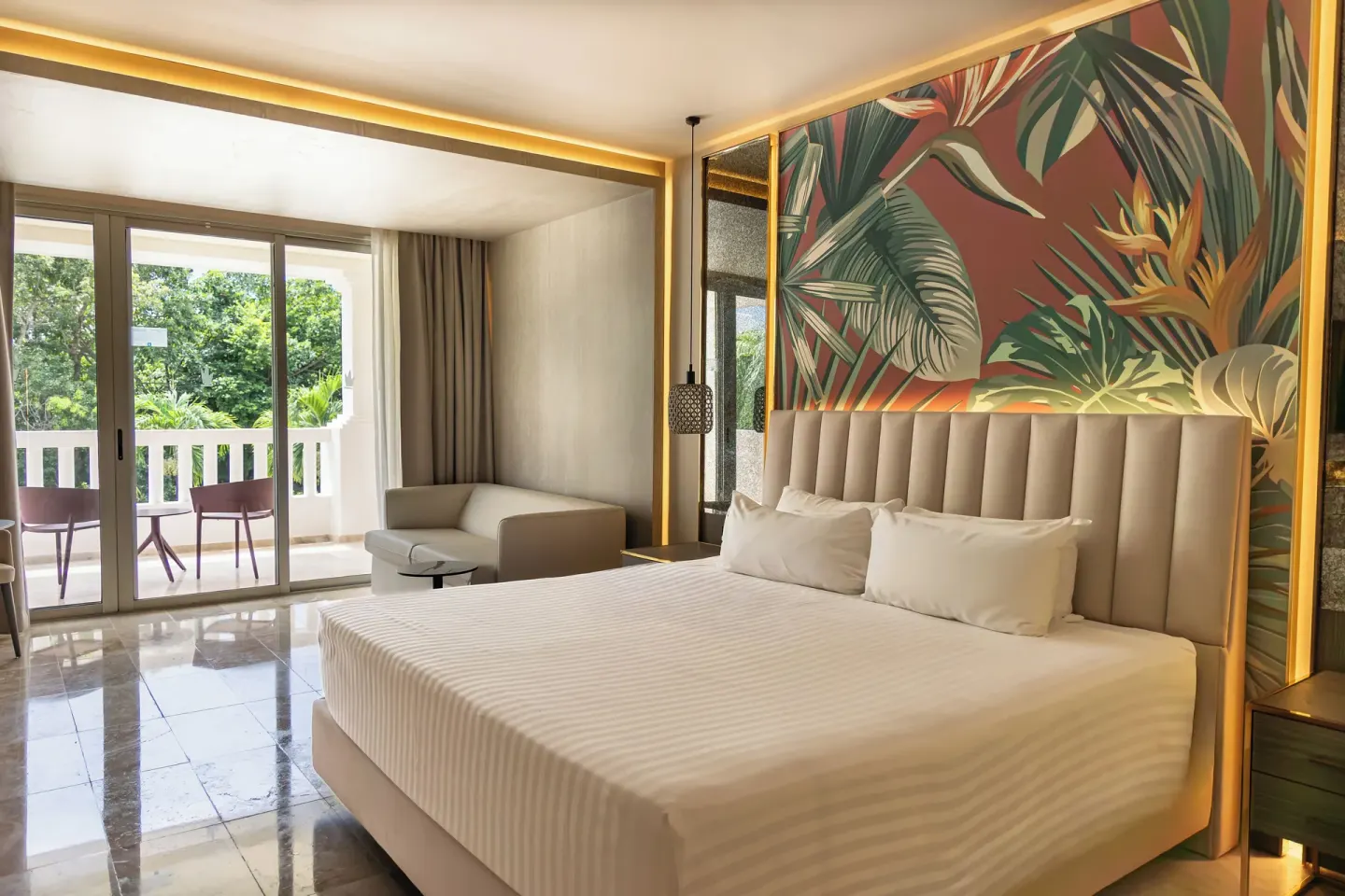 King bed guest room with balcony and tropical wall art at Grand Sunset Princess.