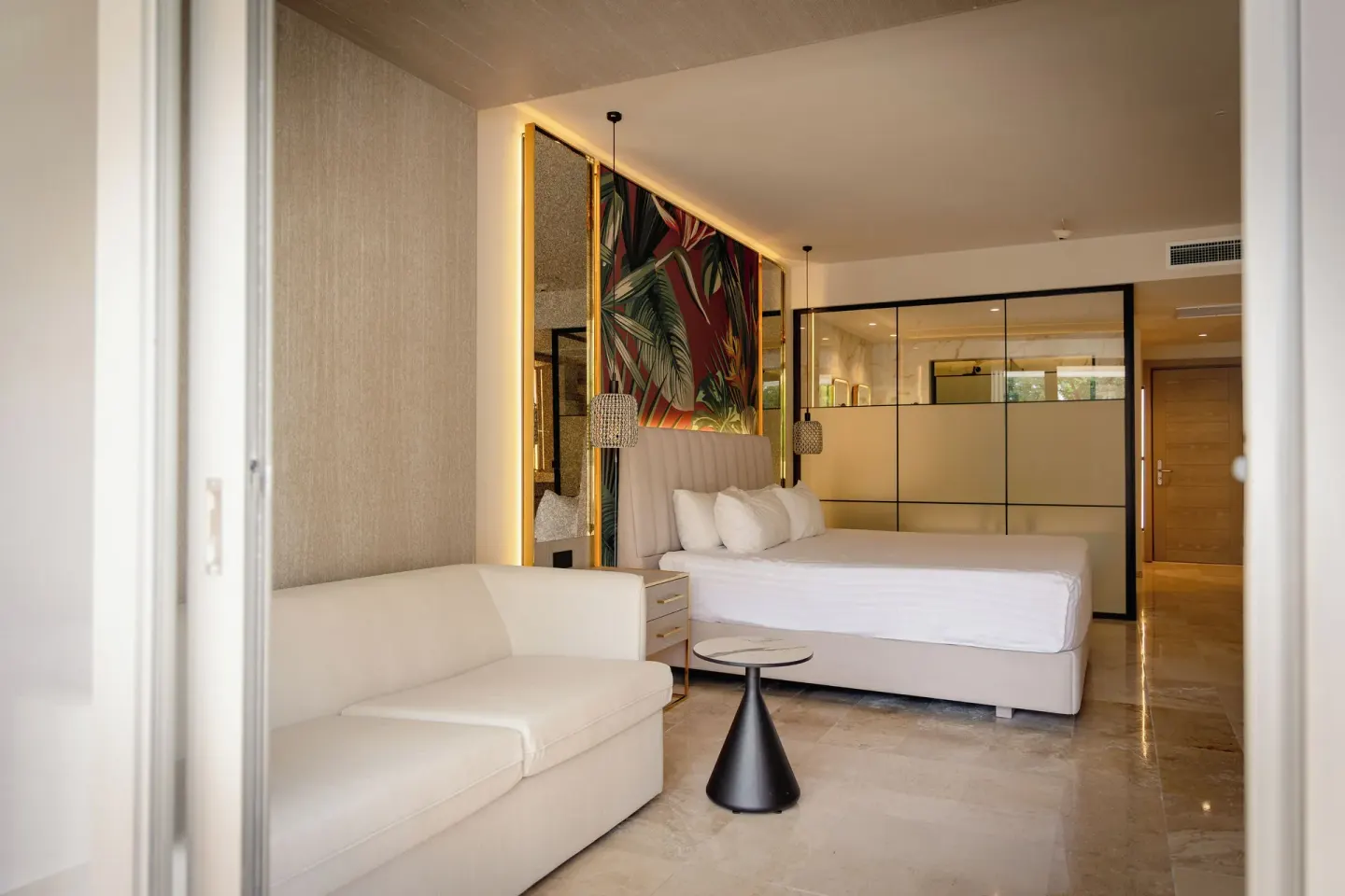Guest room with king bed, sofa and tropical wall art at Grand Sunset Princess.