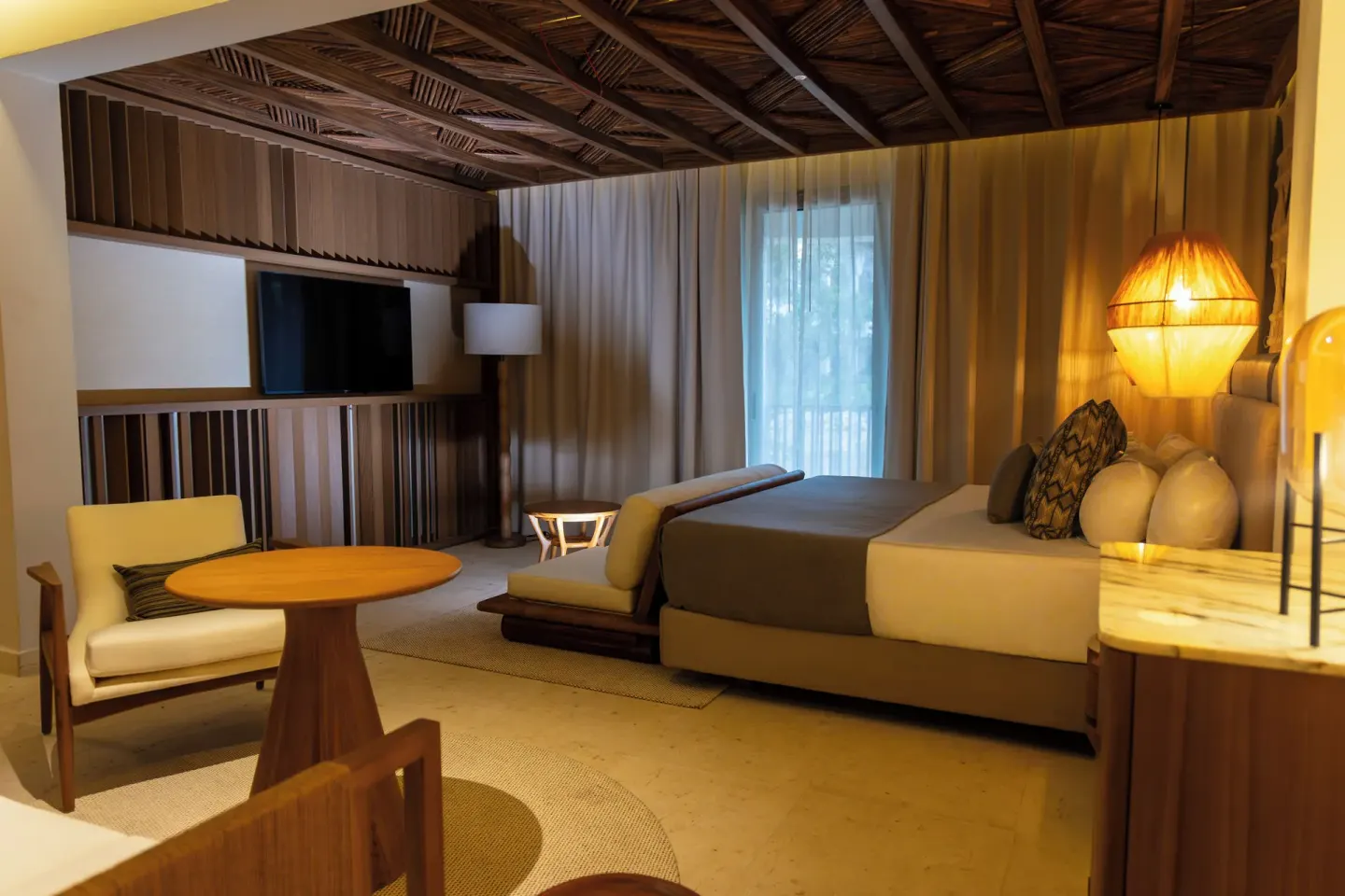 Guest room with king bed, TV wall and round table at Grand Sunset Princess.