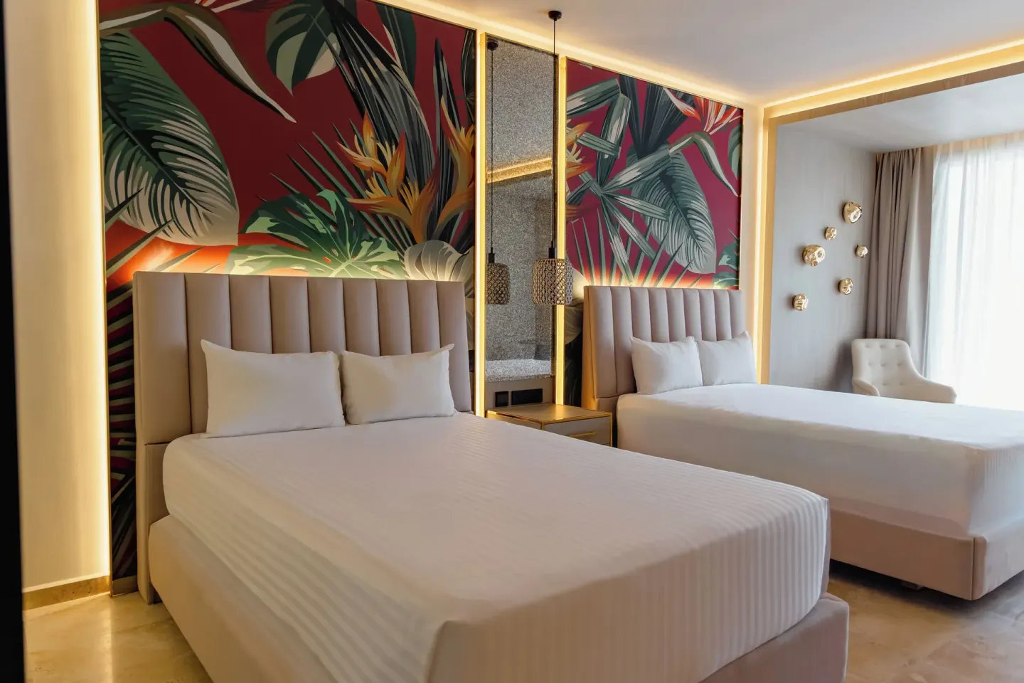 Guest room with two beds, tropical headboard murals and window seating at Grand Sunset Princess.