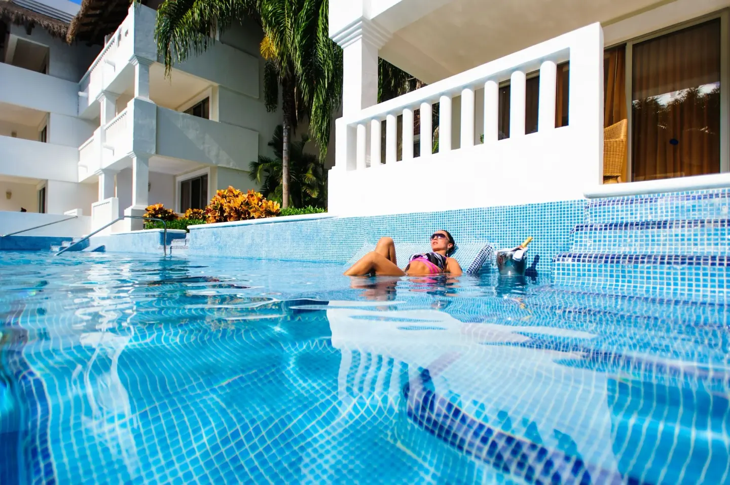Swim-up pool beside white guest room balconies at Grand Sunset Princess.