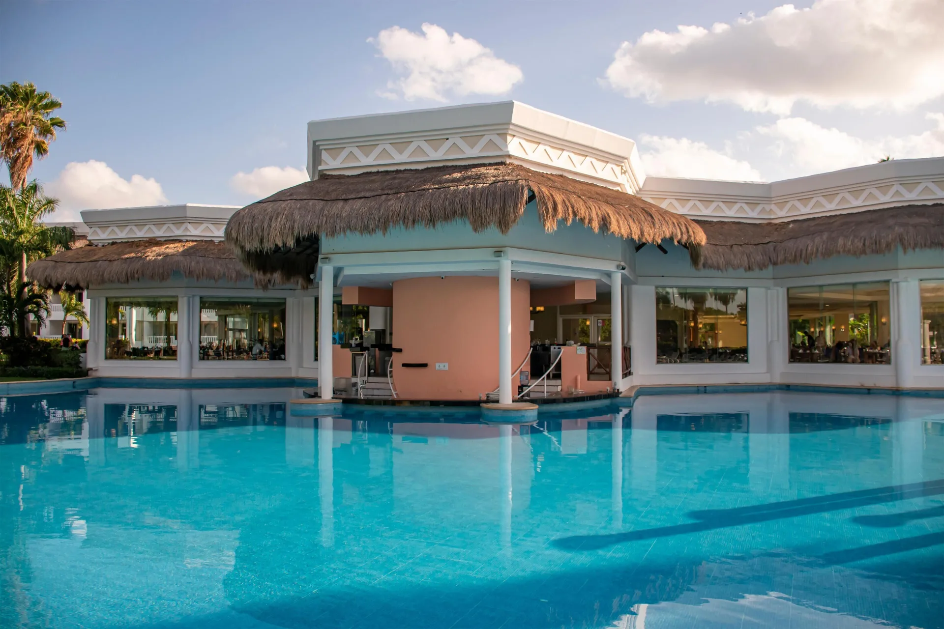 Swim-up pool bar beneath a thatched roof at Grand Sunset Princess.