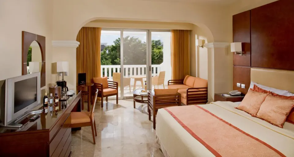 Deluxe Junior Suite with king bed, seating area, TV and balcony at Grand Sunset Princess.