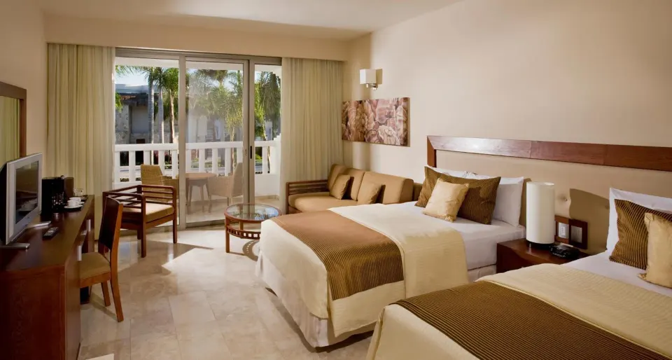 Deluxe Junior Suite with two beds, desk, TV, sofa and balcony at Grand Sunset Princess.