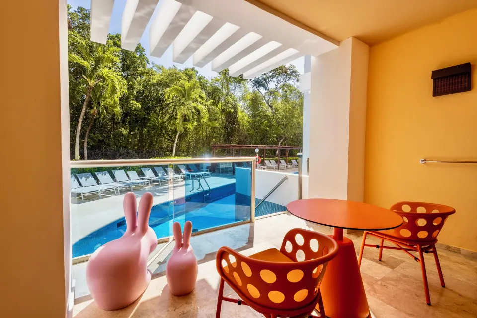 Pool-access terrace with orange chairs at the Family Club Room, Grand Sunset Princess.