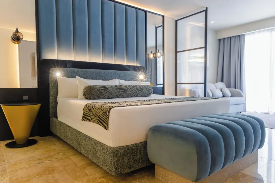 King bed with blue bench in a Platinum Suite Plunge Pool room at Grand Sunset Princess.