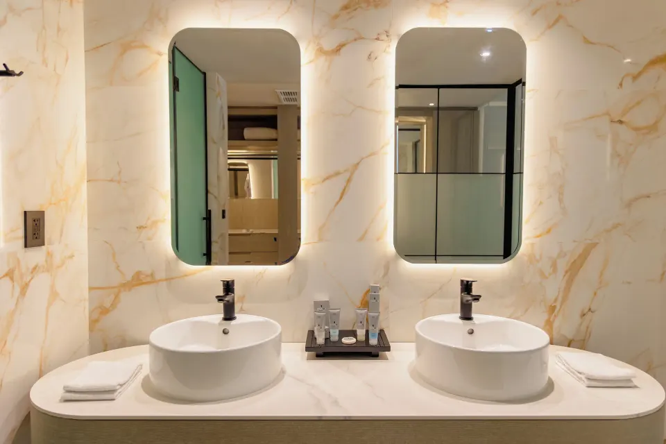 Platinum Suite bathroom with twin vessel sinks and lit mirrors at Grand Sunset Princess.