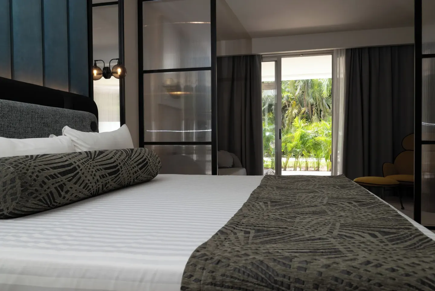 Platinum Suite king bed facing sliding doors and tropical greenery at Grand Sunset Princess.