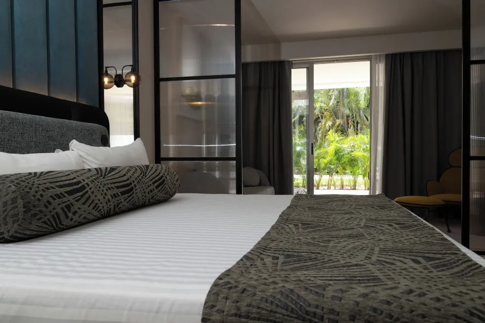 Platinum Suite king bed facing sliding doors and tropical greenery at Grand Sunset Princess.