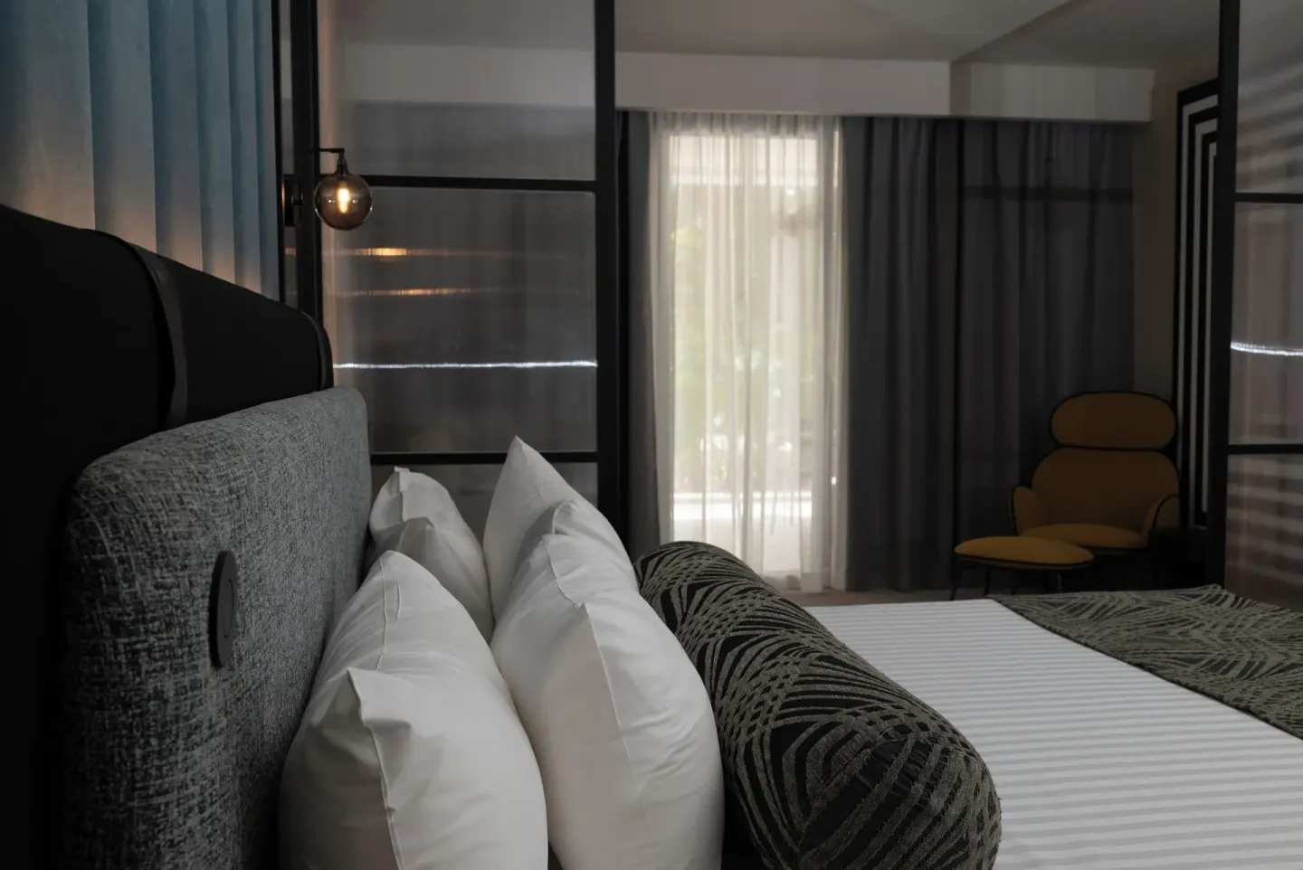 Platinum Suite king bed beside curtains and a lounge chair at Grand Sunset Princess.