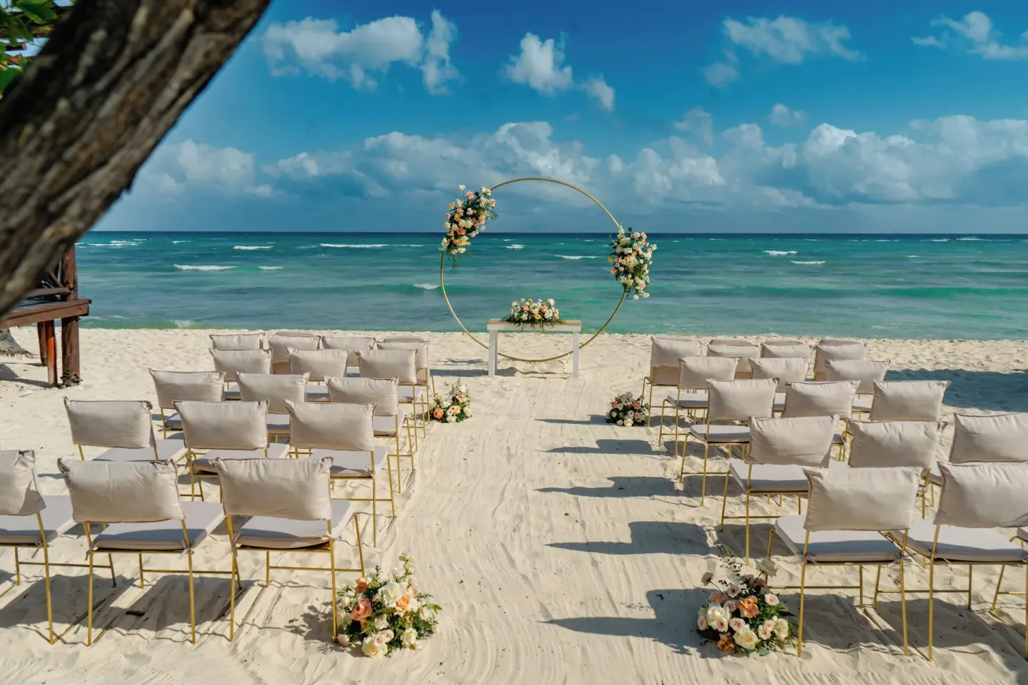 Beach wedding setup with floral arch and ocean backdrop at Grand Sunset Princess.