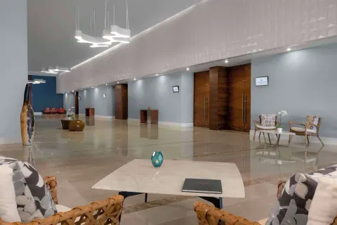 A polished elevator lobby with seating and wood doors at Grand Velas Los Cabos.