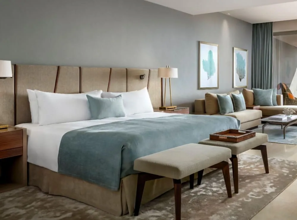 Ambassador Pool Suite king bed and seating area at Grand Velas Los Cabos.