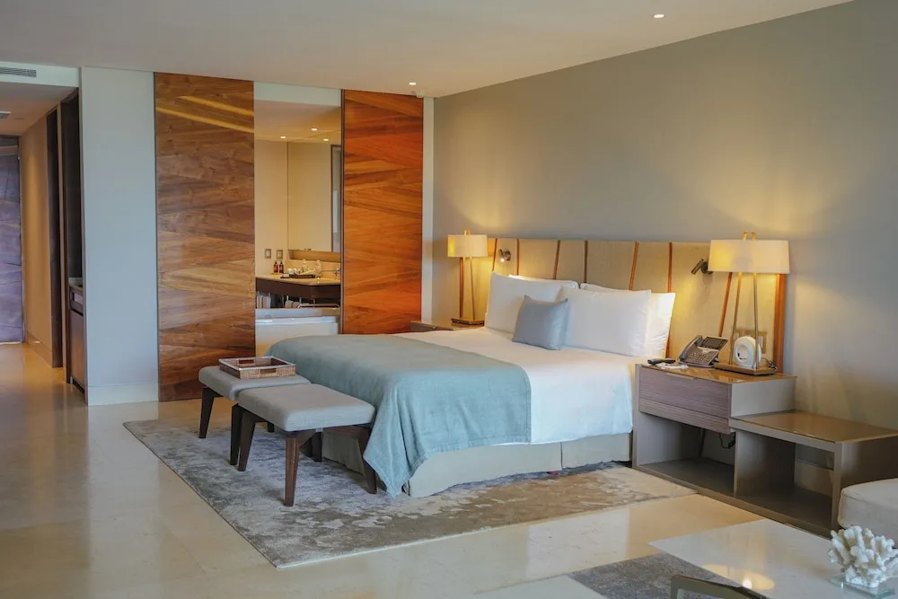 Ambassador Suite Ocean View king bed with wood-paneled bath entry at Grand Velas Los Cabos.