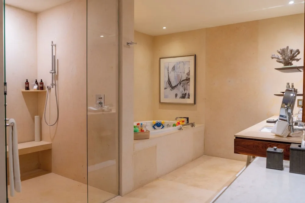 Family Duplex bathroom with glass shower, tub, and vanity at Grand Velas Los Cabos.