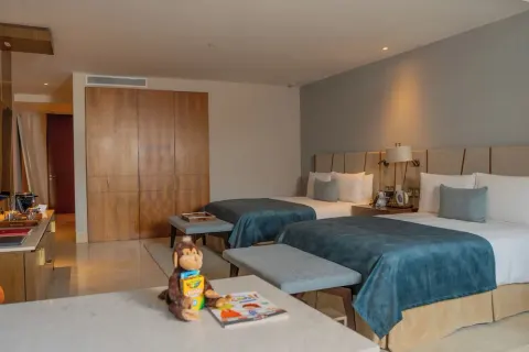 Family Duplex bedroom with two beds, wardrobe, and kids' items at Grand Velas Los Cabos.