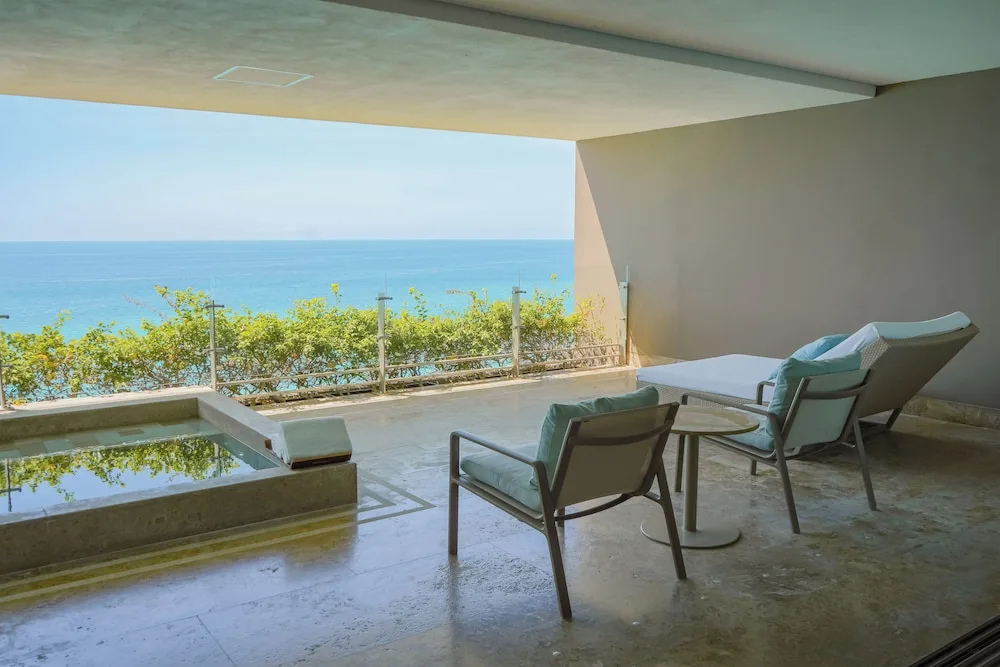 Grand Class Corner Suite terrace with plunge pool, chairs, lounger and ocean view at Grand Velas Los Cabos.
