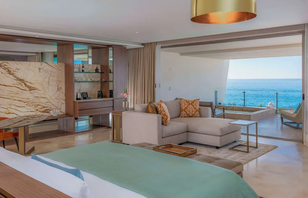 Grand Class Suite Ocean Front king bed, sitting area, and ocean terrace at Grand Velas Los Cabos.