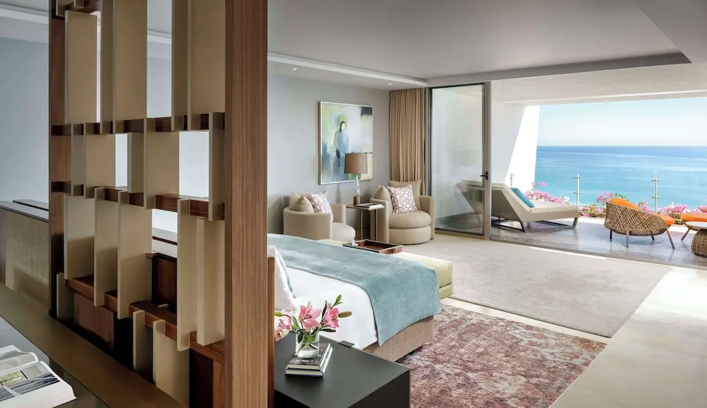 One Bedroom Governor Suite bedroom and terrace lounge facing the ocean at Grand Velas Los Cabos.