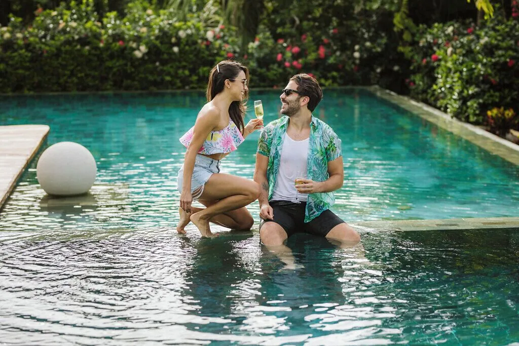 Couple sitting in a garden pool with drinks at Grand Velas Riviera Maya.