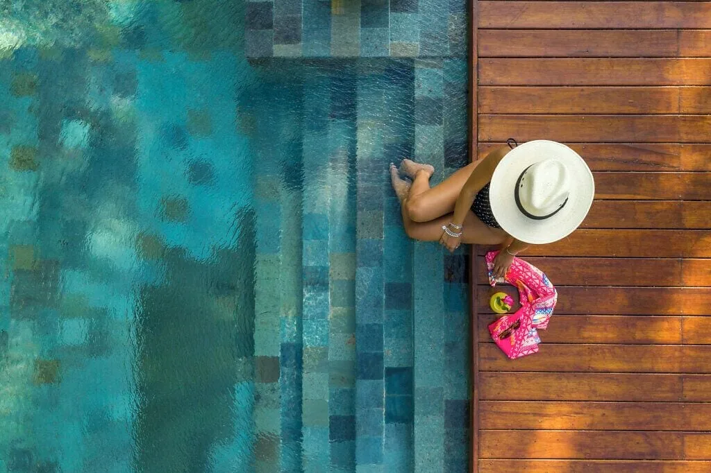 Overhead view of a guest by blue pool steps and a wood deck at Grand Velas Riviera Maya.