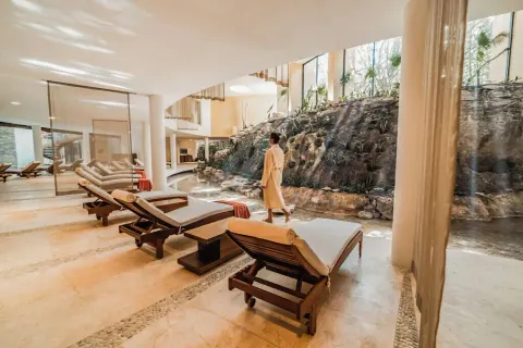 Spa relaxation area with loungers and a rock wall at Grand Velas Riviera Maya.