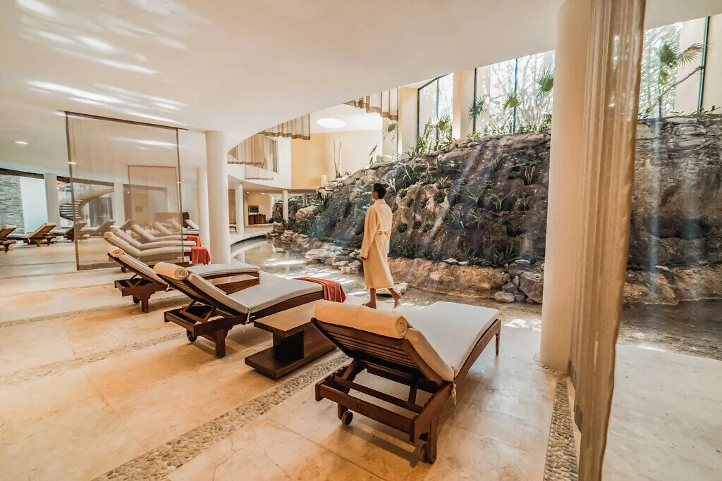 Spa relaxation area with loungers and a rock wall at Grand Velas Riviera Maya.