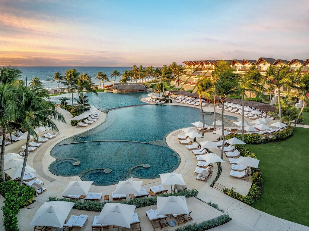 Sunset view of the main pool terraces and ocean beyond at Grand Velas Riviera Maya.