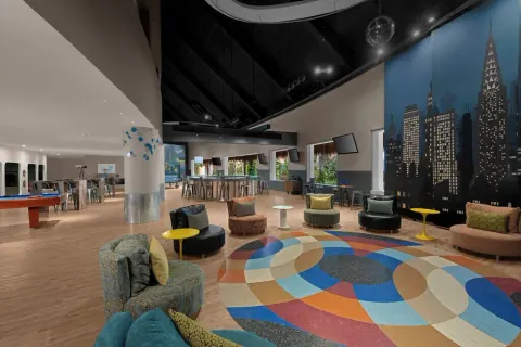 Teen lounge with city mural, pool table and colorful seating at Grand Velas Riviera Maya.