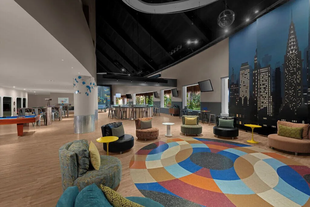 Teen lounge with city mural, pool table and colorful seating at Grand Velas Riviera Maya.
