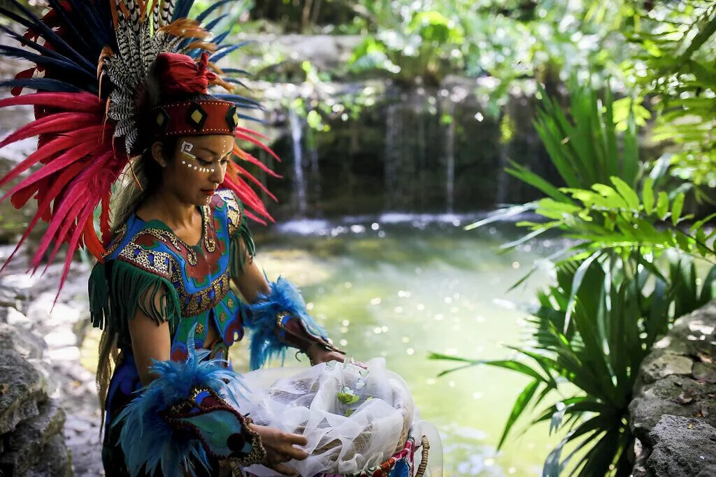 Costumed performer by a tropical water feature at Grand Velas Riviera Maya.