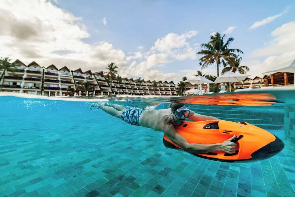 Swimmer uses an orange pool board by the steps at Grand Velas Riviera Maya.