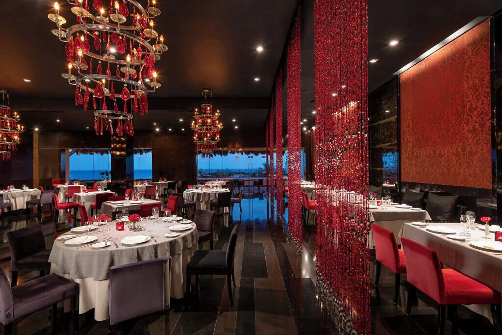 Piaf dining room with red chandeliers and ocean view at Grand Velas Riviera Maya.