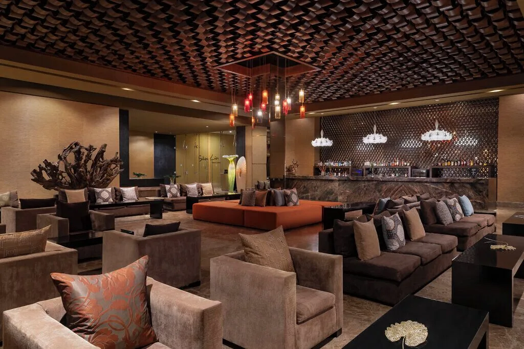 Sen Lin Bar lounge with sofas, patterned ceiling, and backlit bar at Grand Velas Riviera Maya.