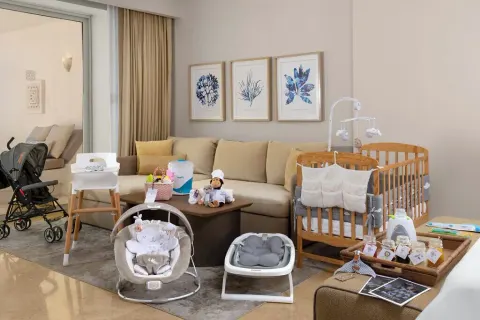 Family suite living area with crib and baby gear at Grand Velas Riviera Maya.