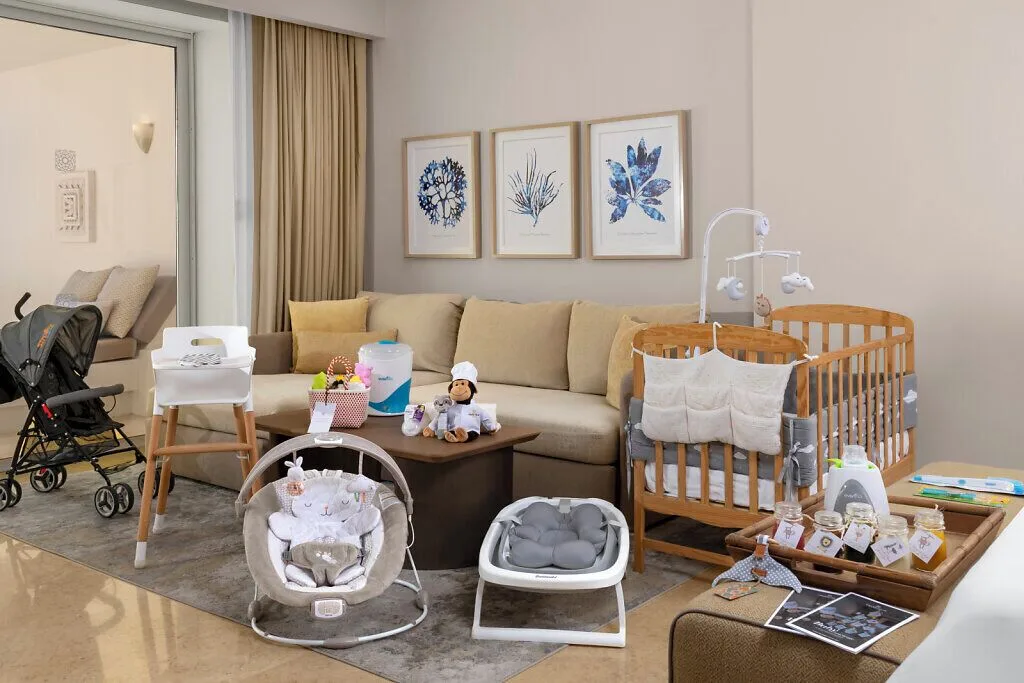 Family suite living area with crib and baby gear at Grand Velas Riviera Maya.