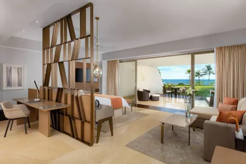 Grand Class Pool Suite with desk, king bed, sofa and oceanfront terrace at Grand Velas Riviera Maya.