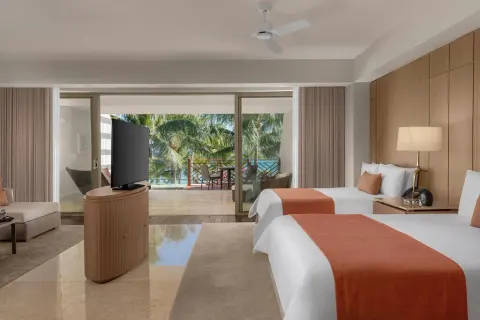 Grand Class Pool Suite with two beds, TV and terrace facing palms at Grand Velas Riviera Maya.