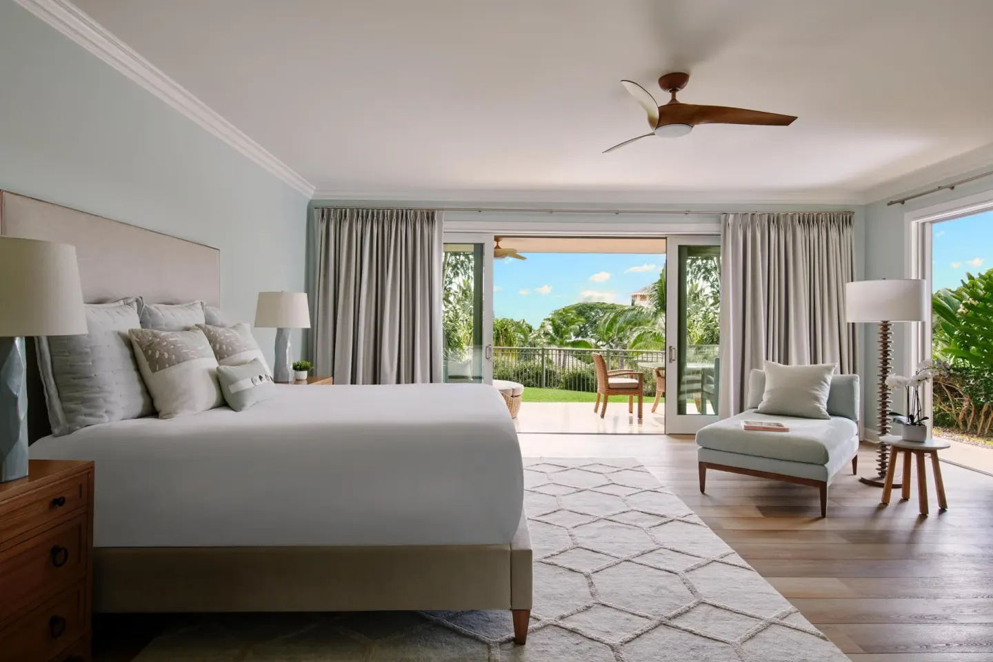 Guest room with a king bed, chaise, and terrace doors at Grand Wailea Maui.