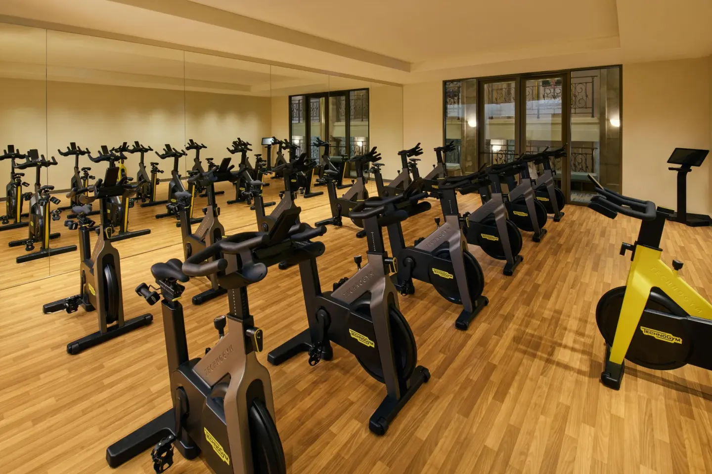 Indoor cycling studio with rows of stationary bikes and mirrored wall at Grand Wailea Maui.