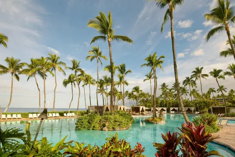 Palm-lined resort pool with ocean beyond at Grand Wailea Maui.