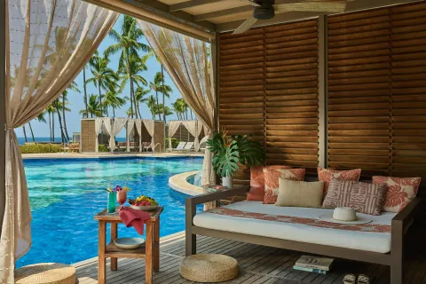 Poolside cabana with daybed, drinks, fruit and ocean palms at Grand Wailea Maui.