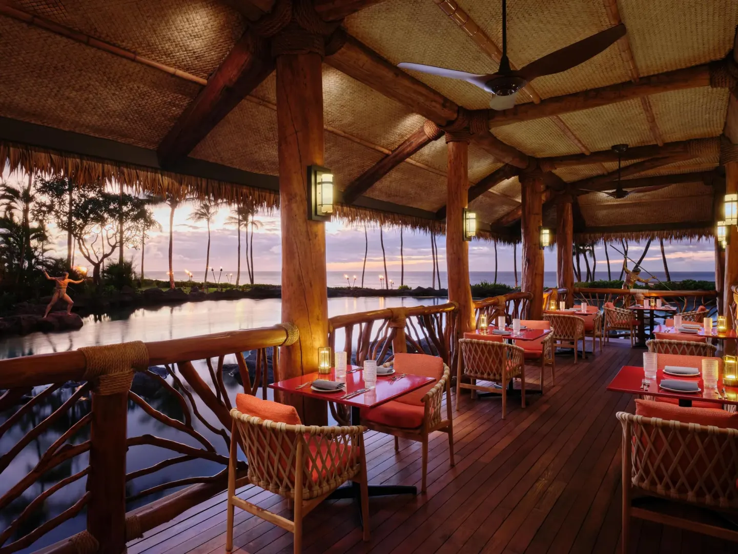 Waterfront dining lanai with thatched roof at Grand Wailea Maui.