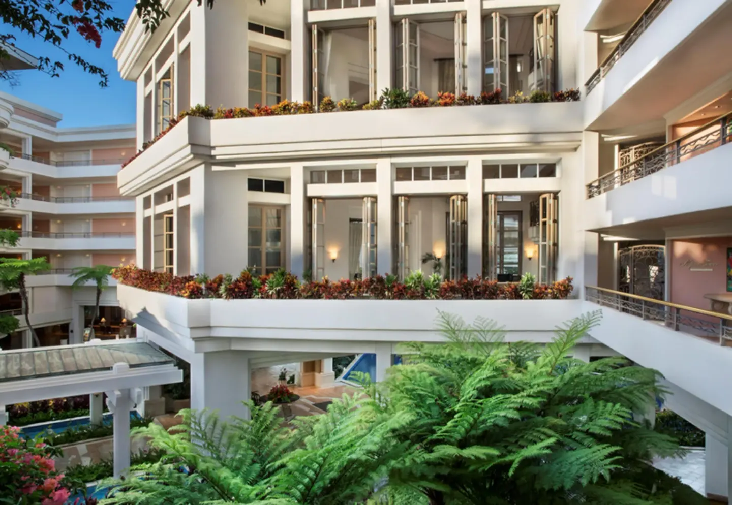 Napua tower exterior with balconies, open windows, and tropical plantings at Grand Wailea Maui.