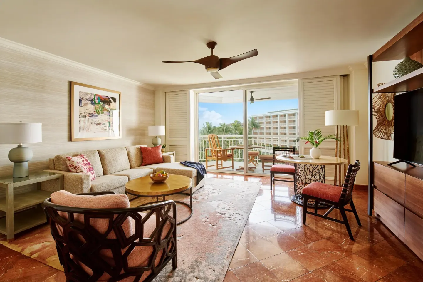 Club Suite living room with sofa, dining table, TV, and balcony at Grand Wailea Maui.